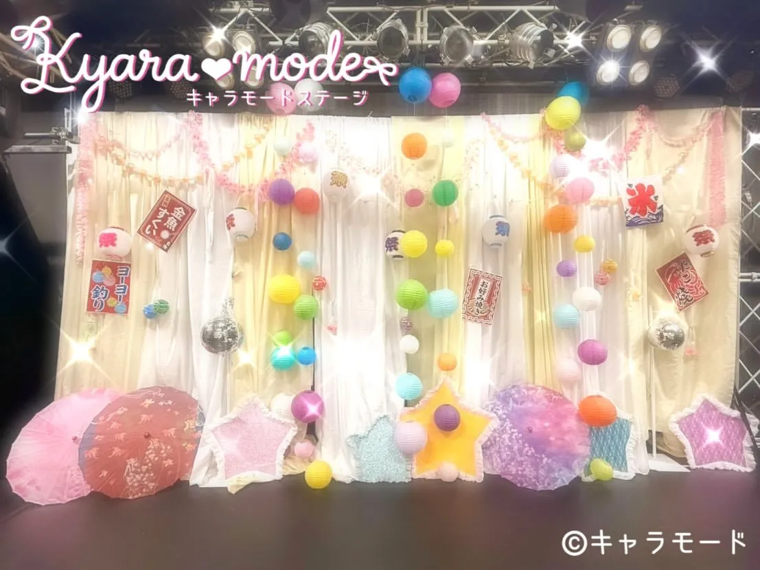 白いカーテンにカラフルな風船や提灯、和傘を飾ったお祭り風の生誕祭ステージ